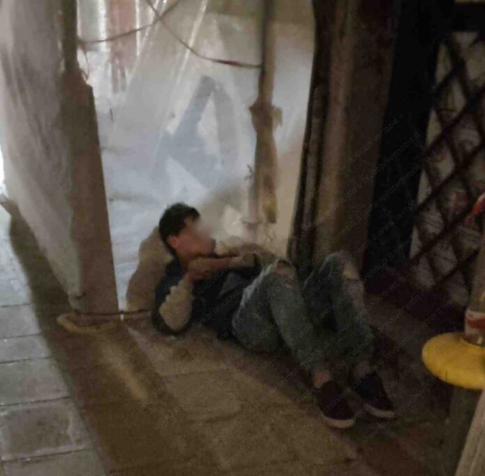 Nella foto inviata da un lettore, un giovane dorme sotto un'impalcatura per restauri dopo una festa al Morion