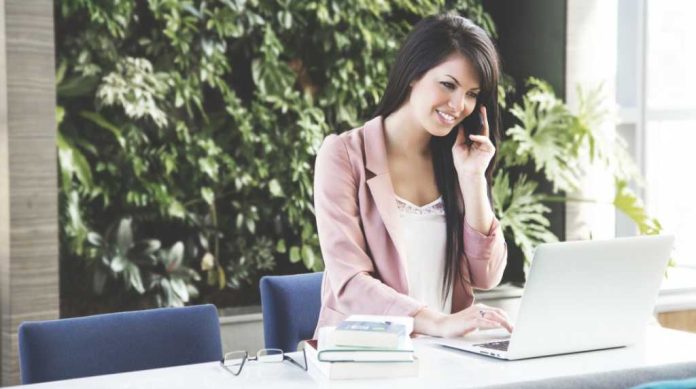 Ragazza in ufficio al telefono lavora con il pc Ragazza in ufficio al telefono lavora con il pc