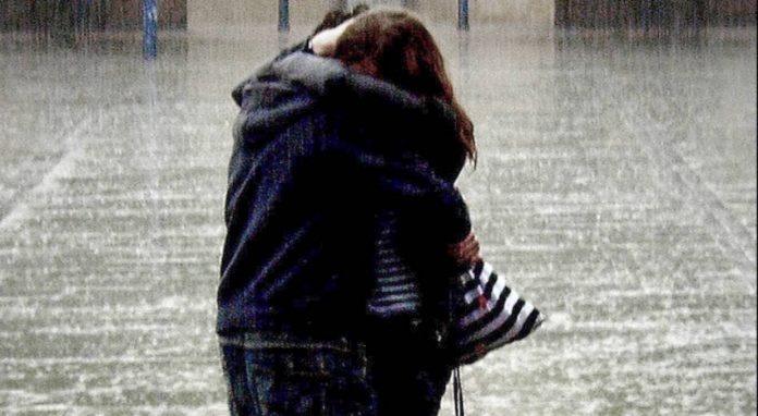 abbraccio, due giovani si abbracciano sotto le pioggia net fee 1240