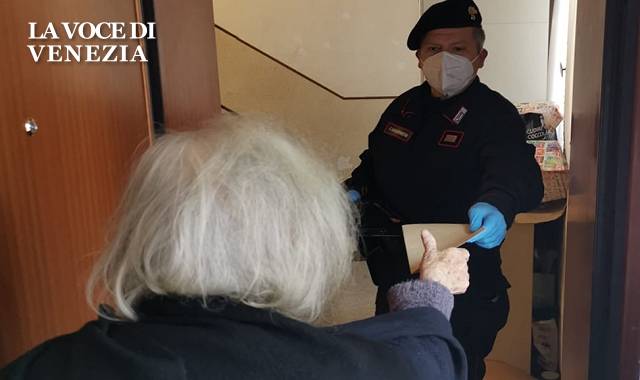 carabiniere con mascherina consegna busta anziana sulla porta up 640
