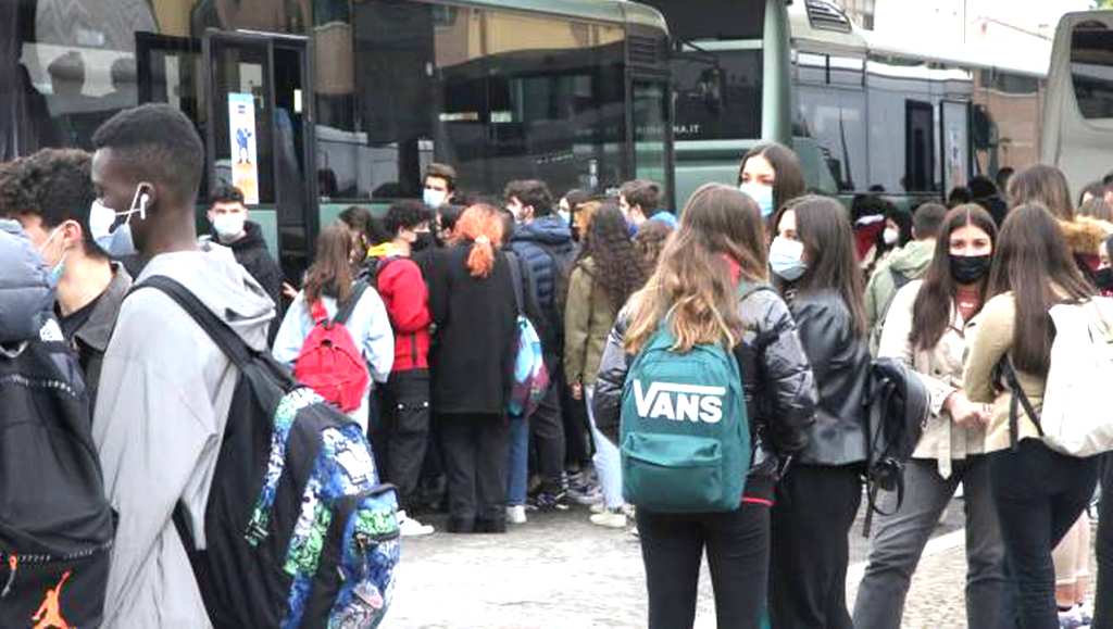 ragazzi studenti prendono l'autobus per andare a scuola con le mascherine