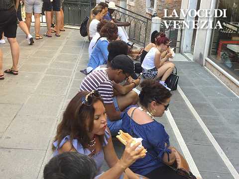 turisti venezia mangiano panino seduti ponte 480360